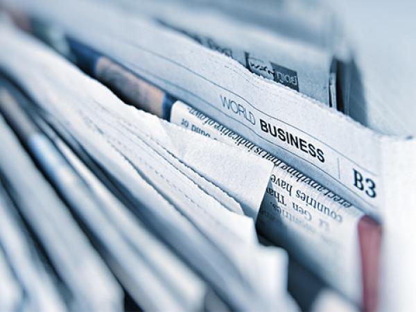 Zeitungen mit Business-Schlagzeile gestapelt
